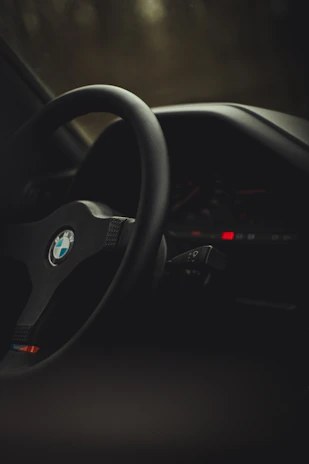 Close-up of diagnostic tools connected to a BMW engine control unit, glowing softly in dark mode lighting.