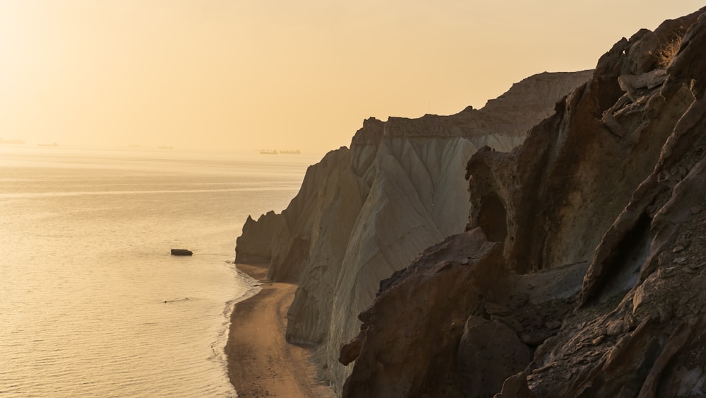 brown rock formation near body of water during daytime