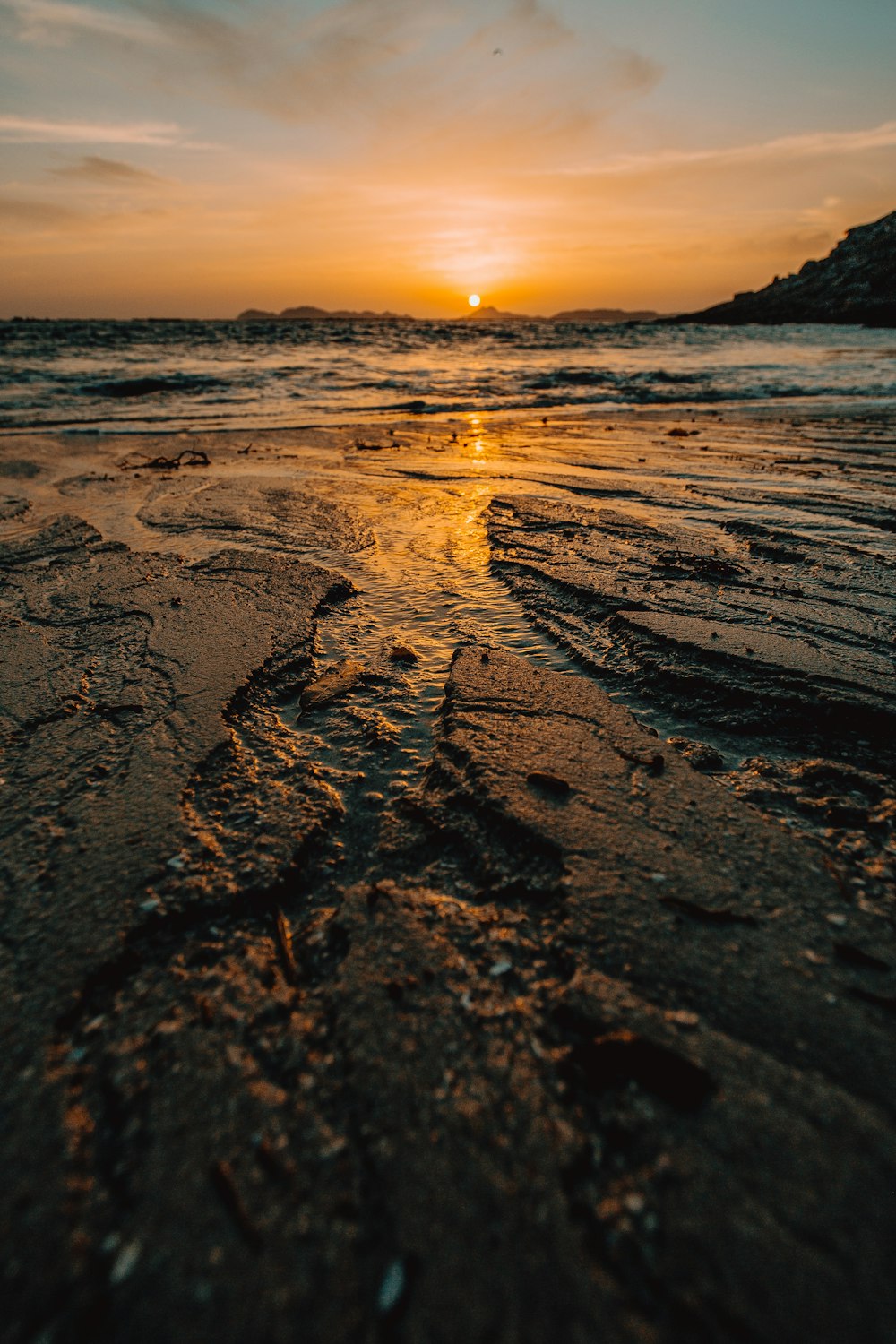 sea waves crashing on shore during sunset