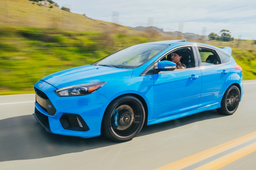 blue 5 door hatchback on road during daytime