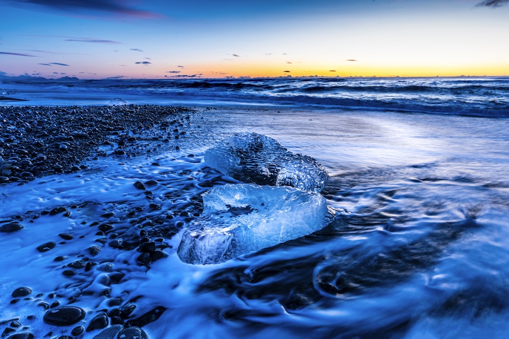 water waves on shore during sunset