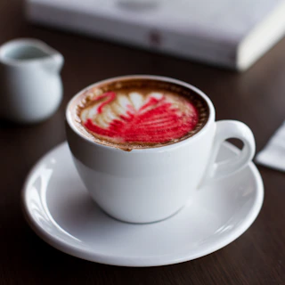 Close-up of a barista carefully pouring latte art into a cup