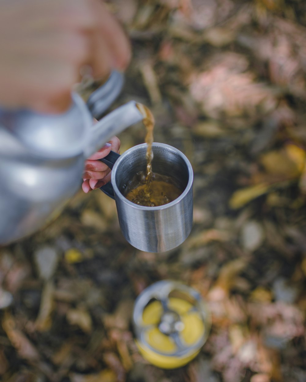 person pouring water on stainless steel cup