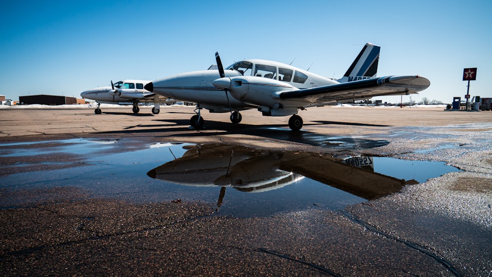 white and blue airplane on brown sand during daytime