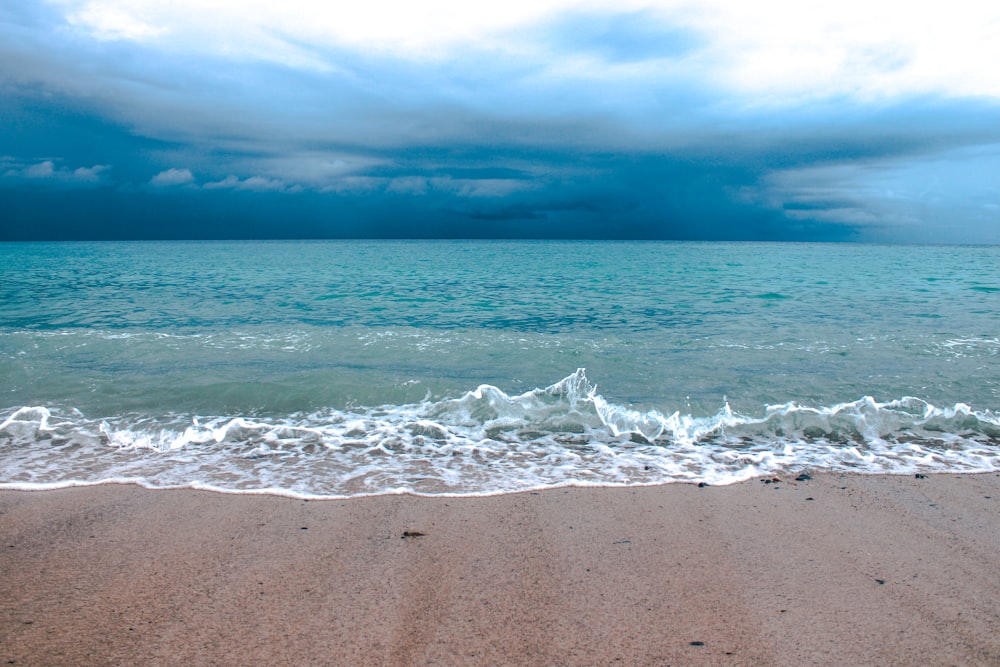 sea waves crashing on shore during daytime