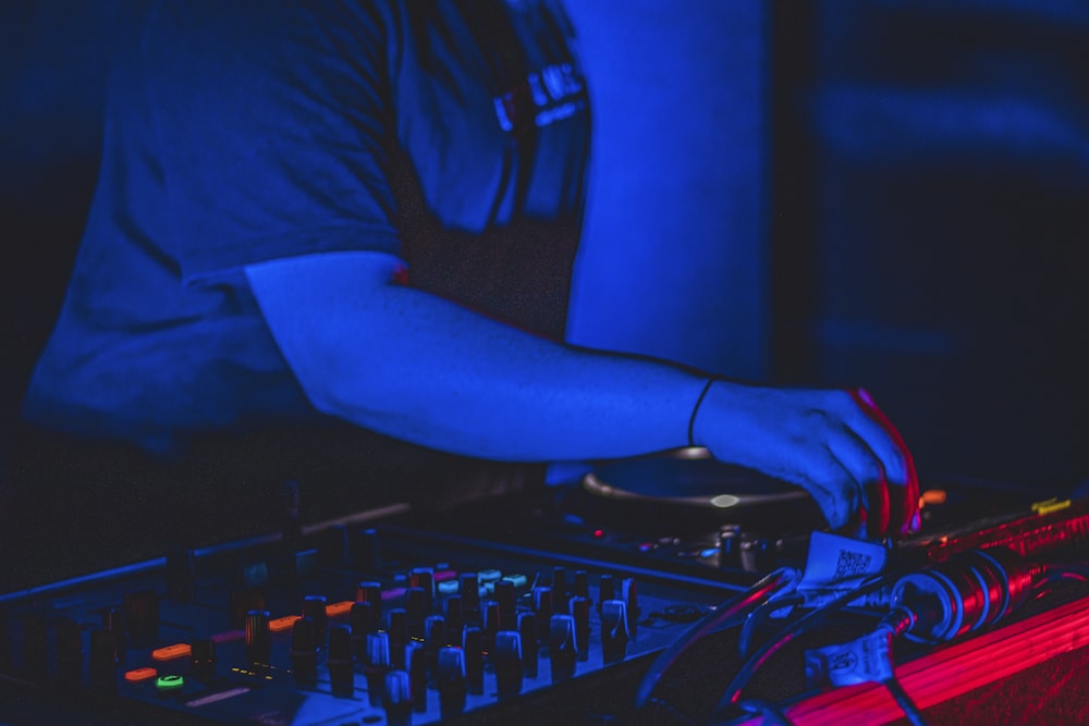 person in black long sleeve shirt using black and red audio mixer