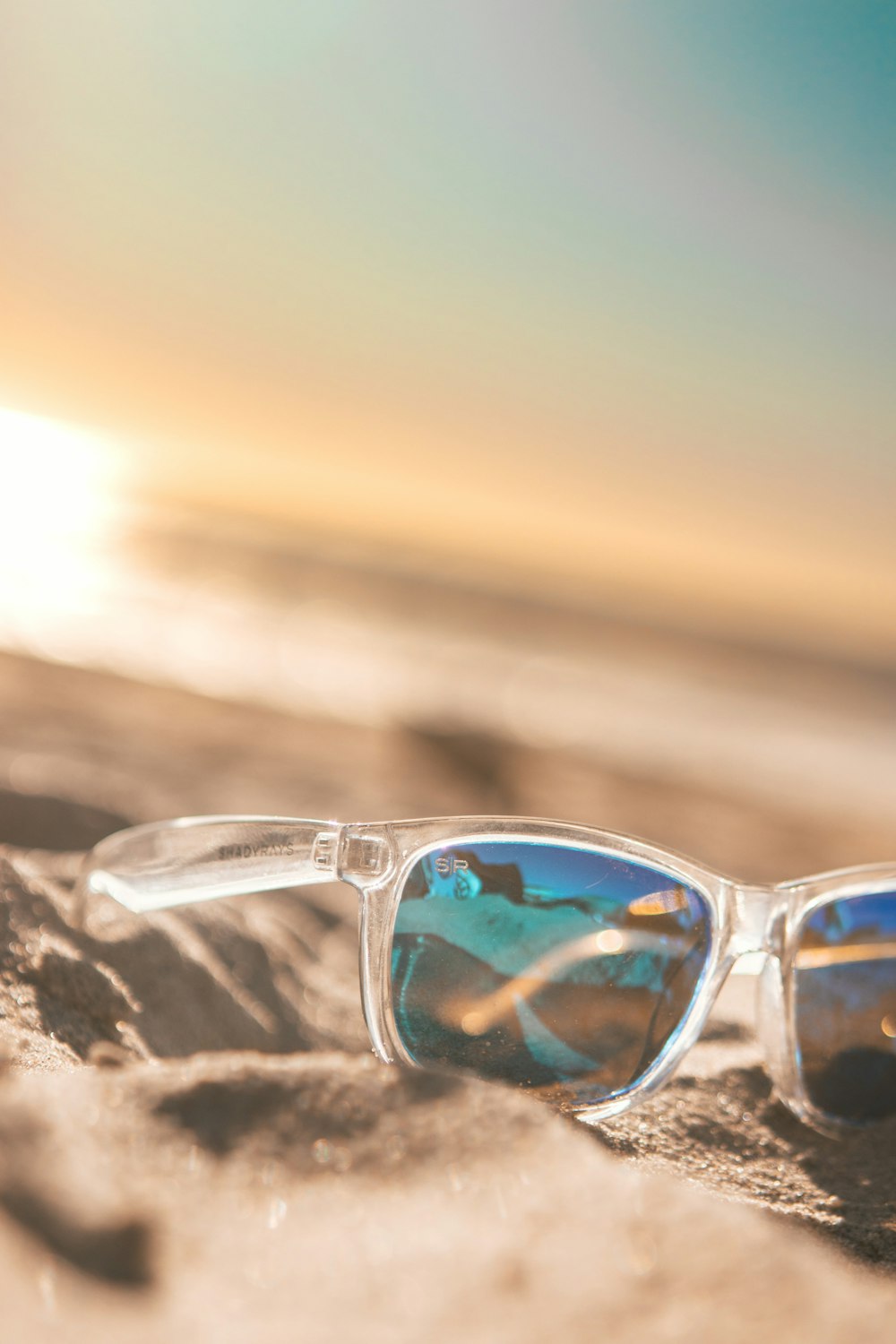 silver framed aviator style sunglasses on brown rock