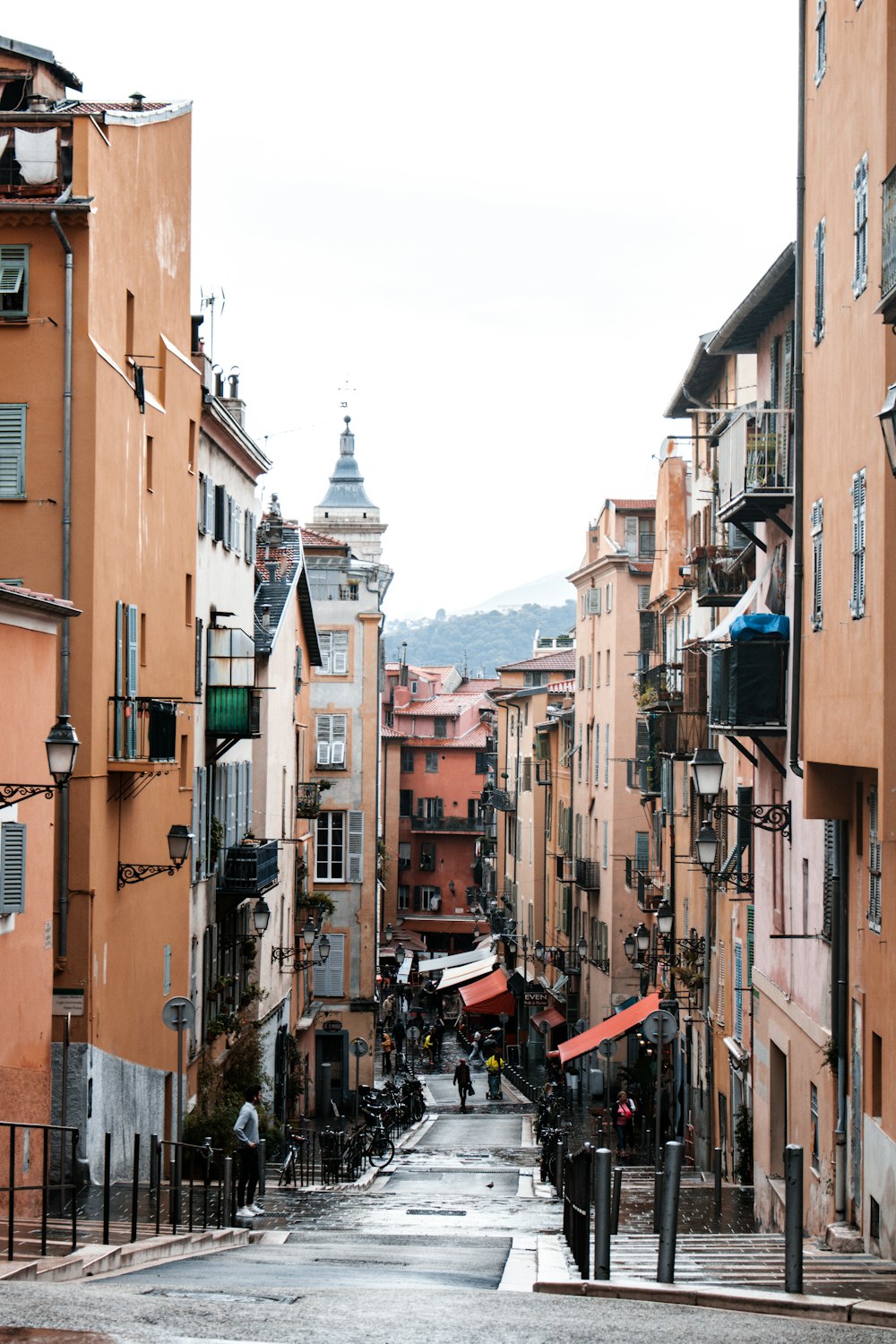 people walking on street between buildings during daytime