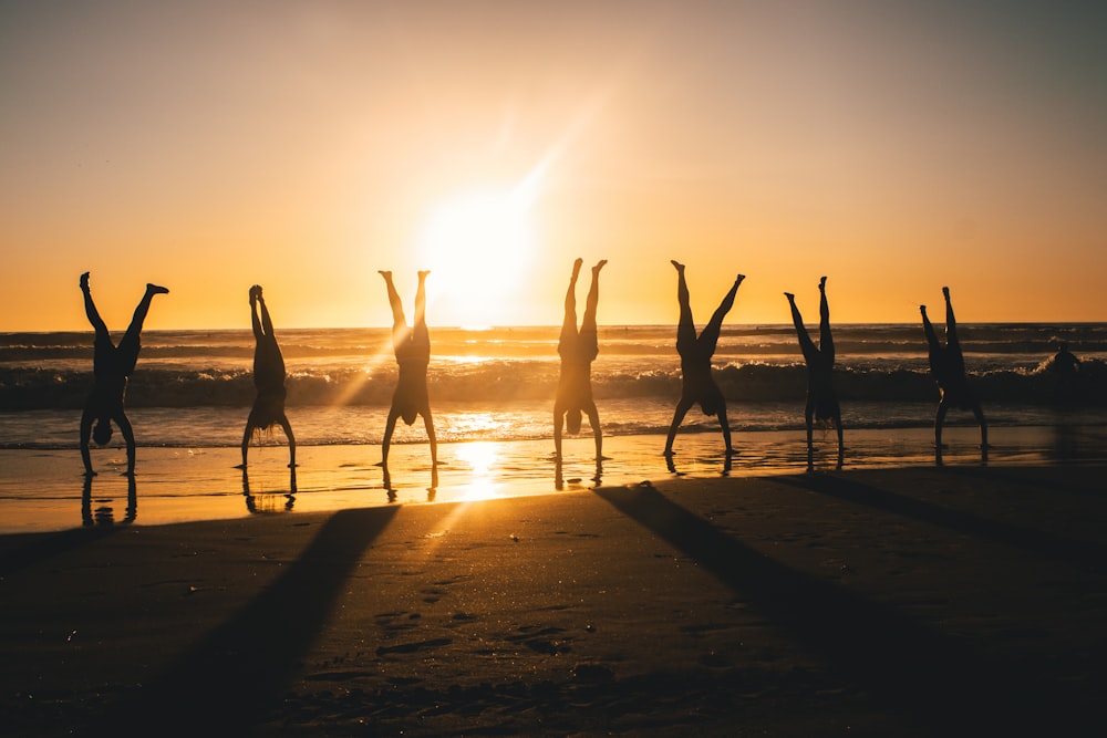 silhouette of people on beach during sunset