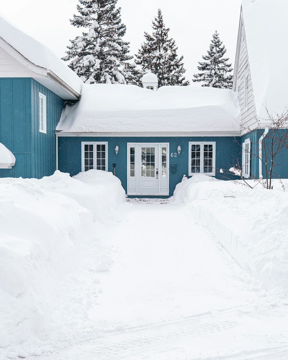 Weißes Holzhaus auf schneebedecktem Boden