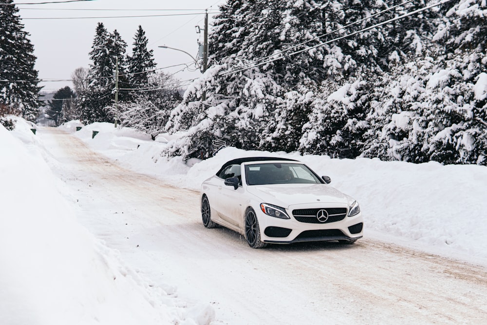 white mercedes benz coupe on snow covered road during daytime