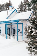 blue and white wooden house covered with snow