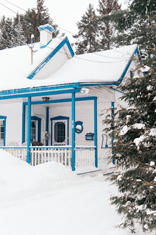 blue and white wooden house covered with snow