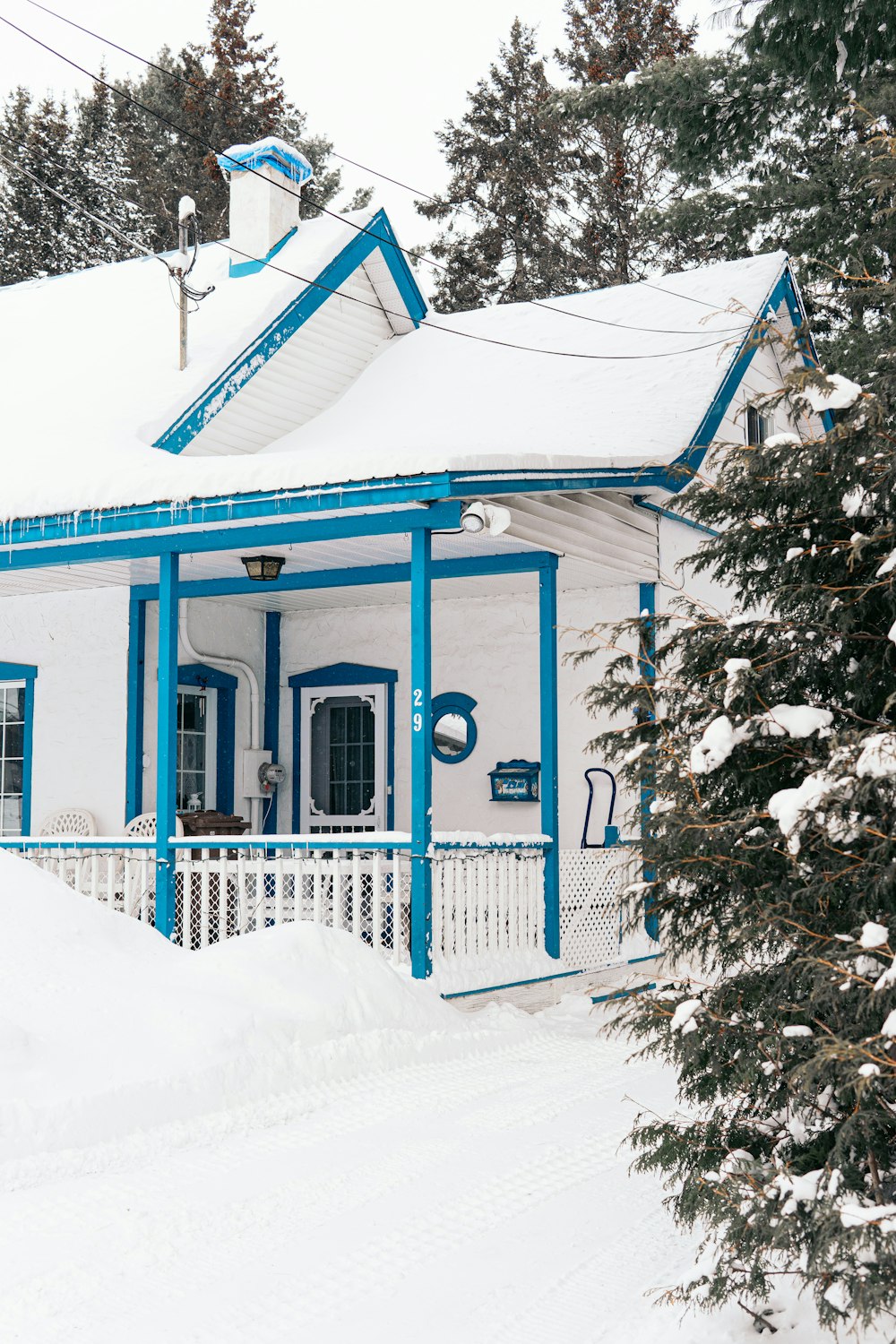 casa di legno blu e bianca ricoperta di neve