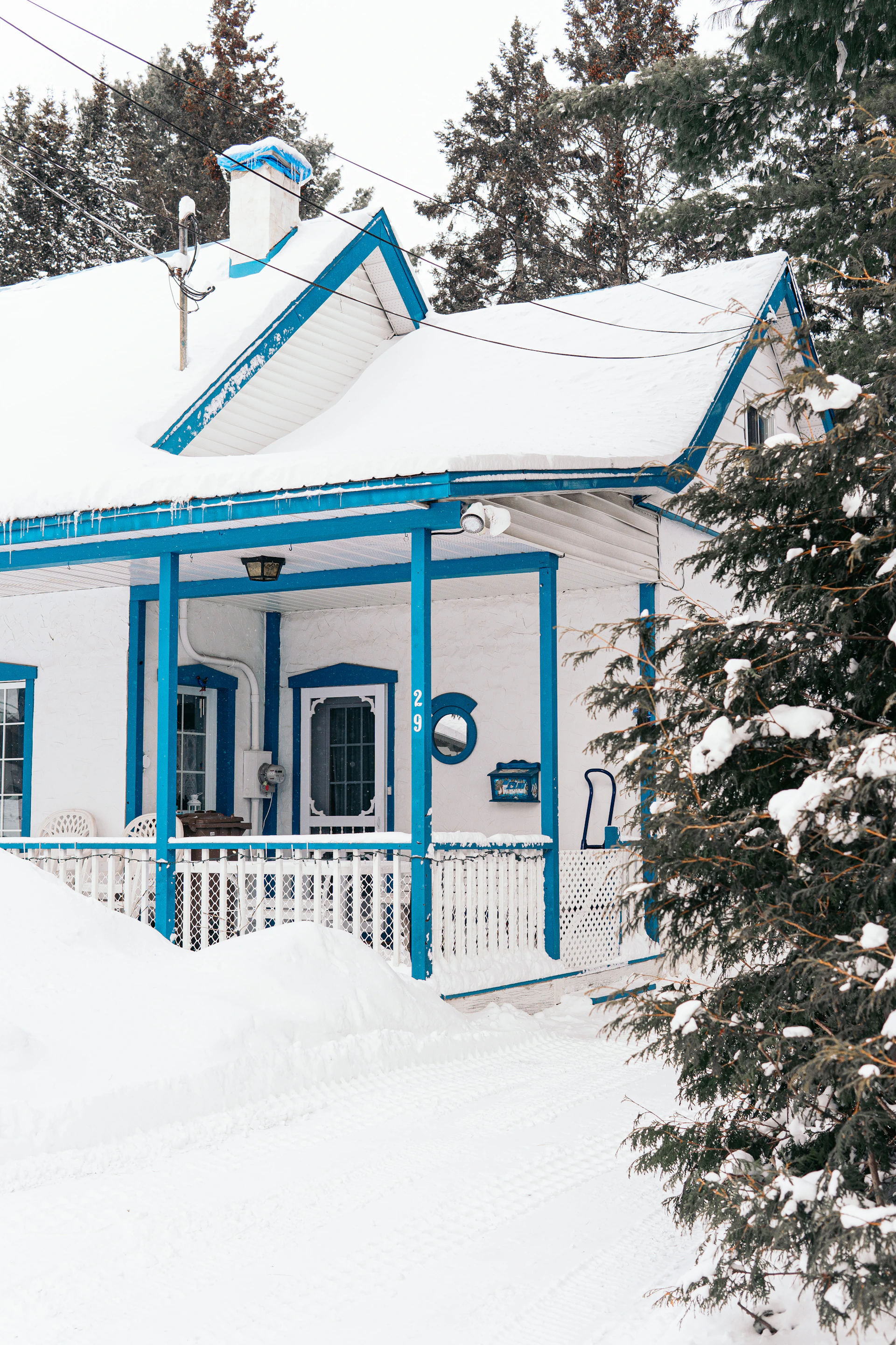 A charming Vail residence showcasing fresh snow removal with clean, safe walkways and driveways framed by evergreen trees dusted with snow.