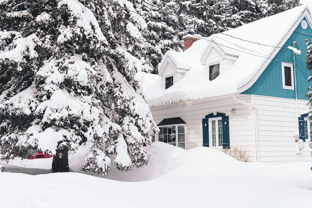 brown house covered with snow near trees during daytime