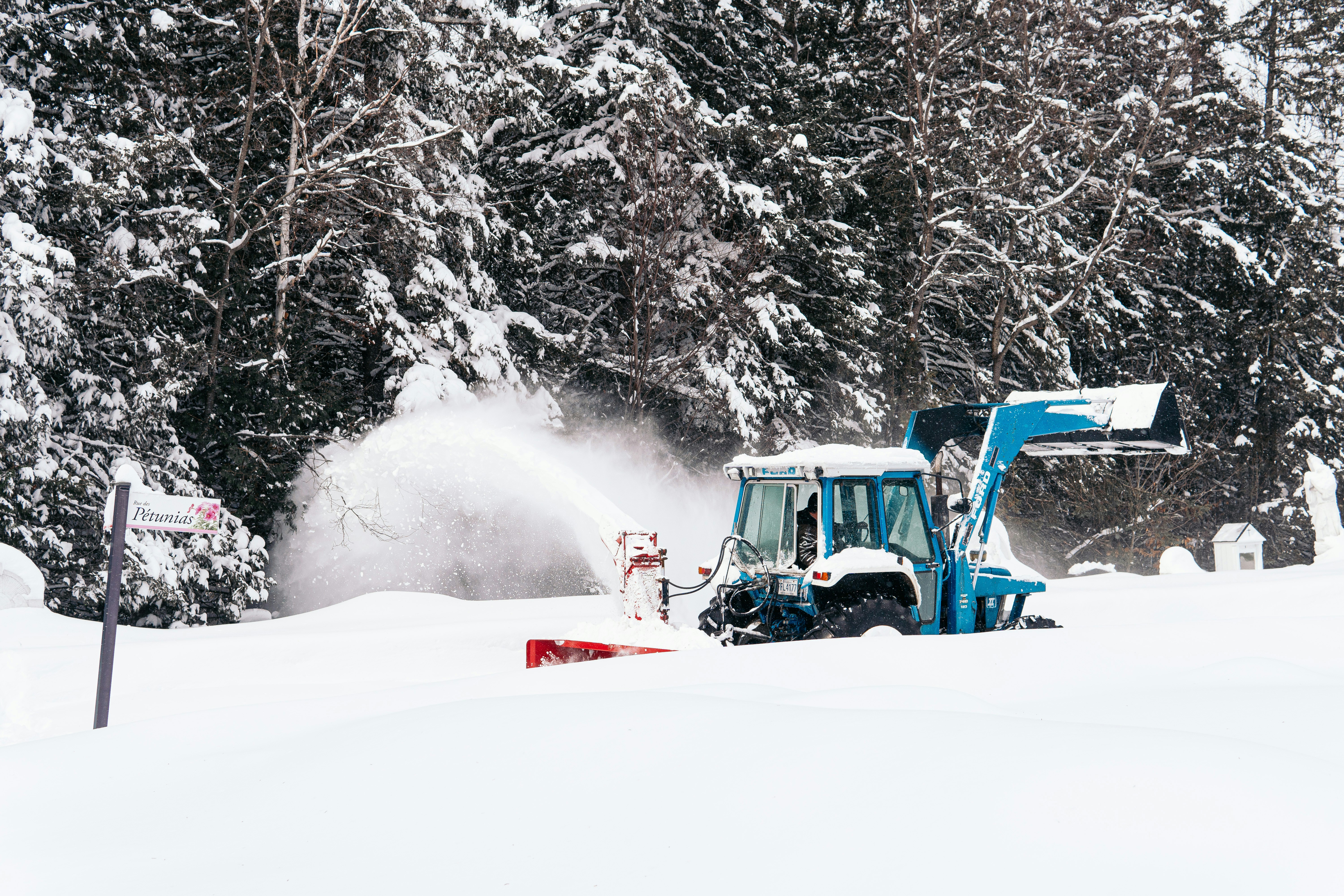 red and black tractor on snow covered ground during daytime