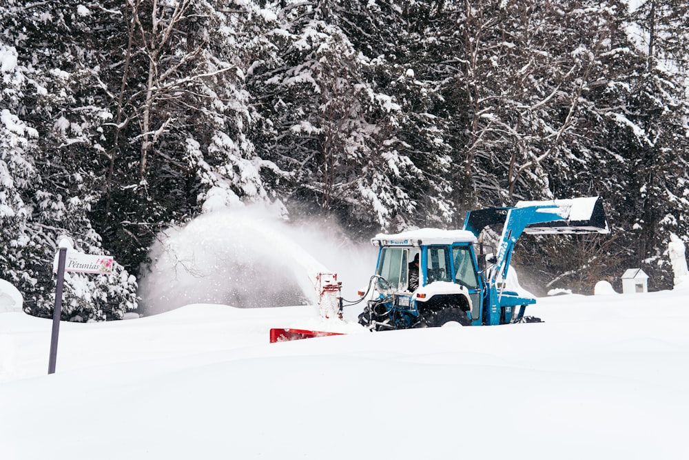 red and black tractor on snow covered ground during daytime