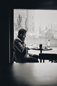 man in black jacket sitting by the table