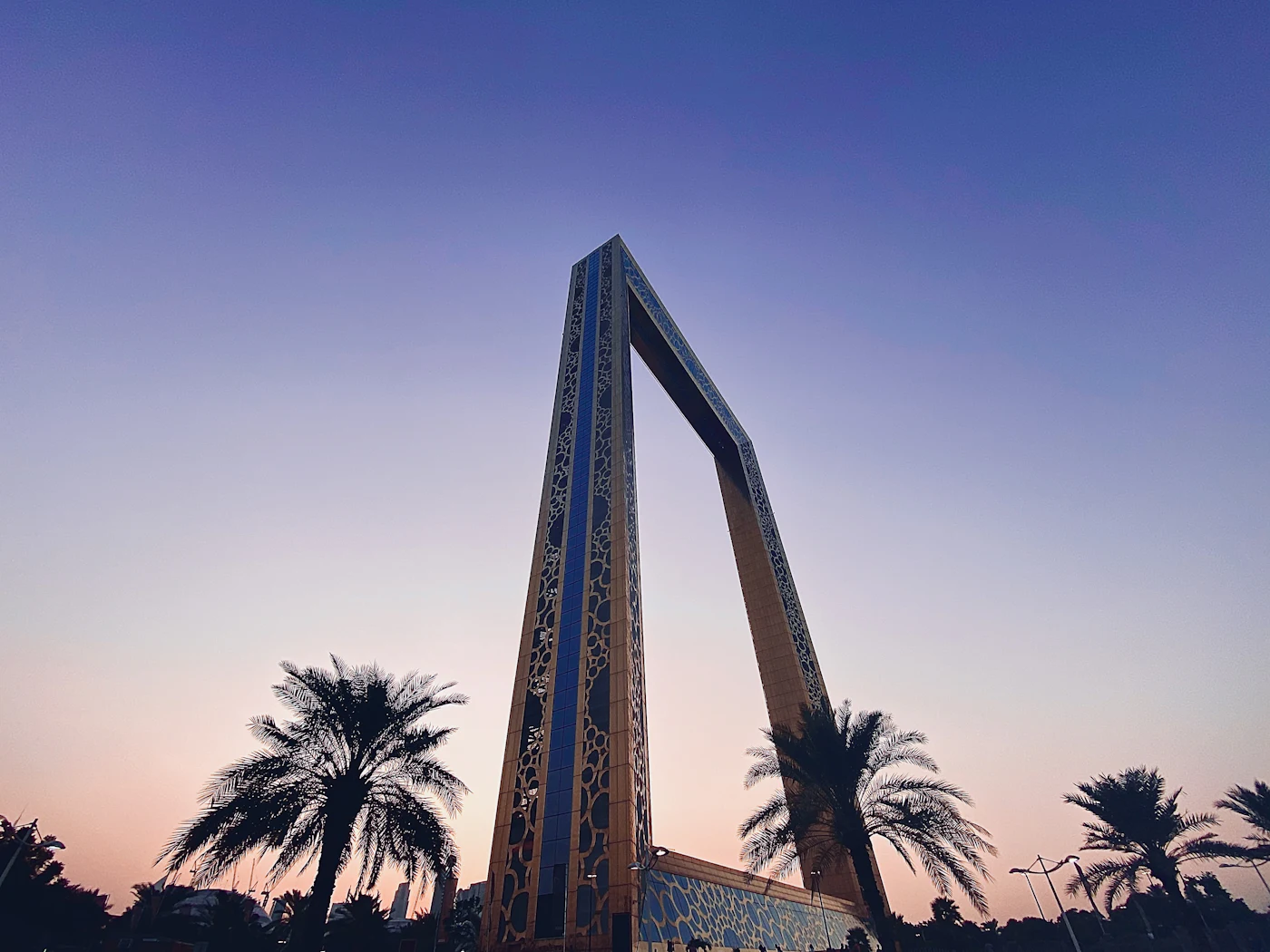 The Dubai Frame and palm trees at dusk