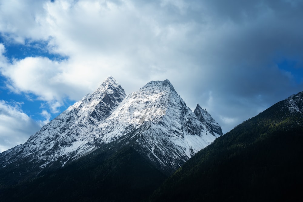 snow covered mountain under cloudy sky during daytime