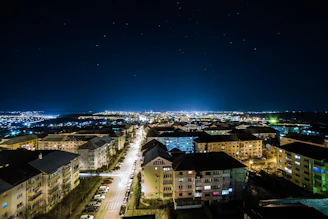 Nighttime aerial photo of Bogor city lights twinkling beneath a starry sky.
