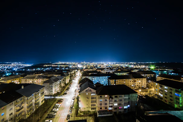 Nighttime aerial photo of Bogor city lights twinkling beneath a starry sky.