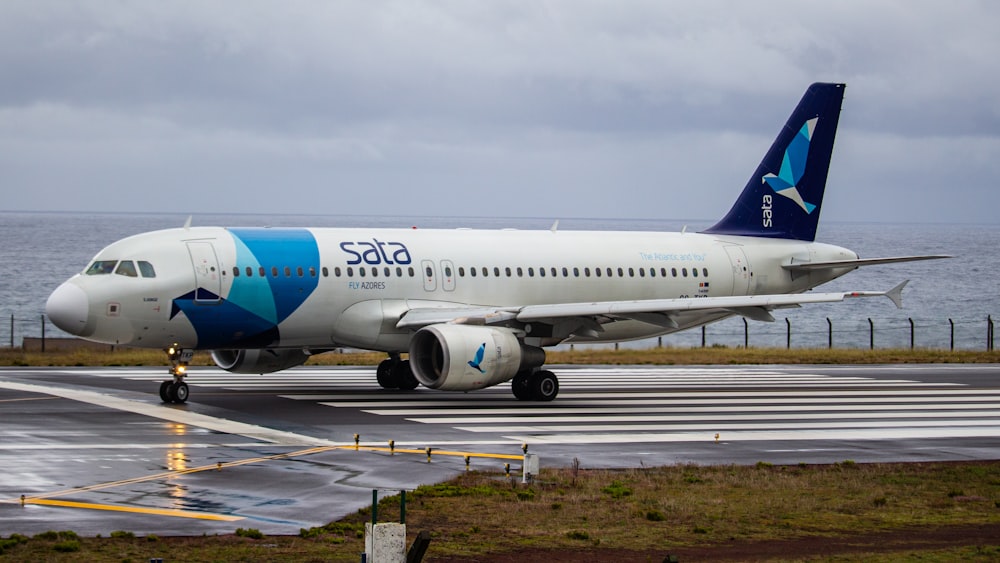 white and blue airplane on airport during daytime