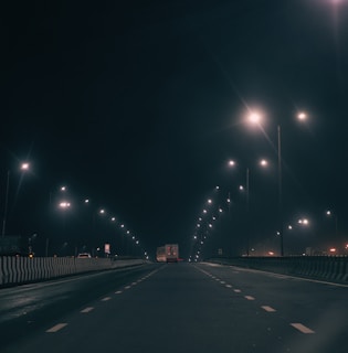 A quiet highway with a tow truck driving under clear skies.