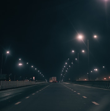 Night view of a CCF Transportes truck driving on a highway with lights on.