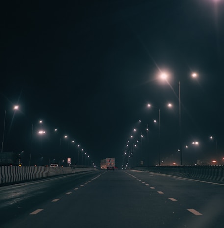 A quiet highway with a tow truck driving under clear skies.