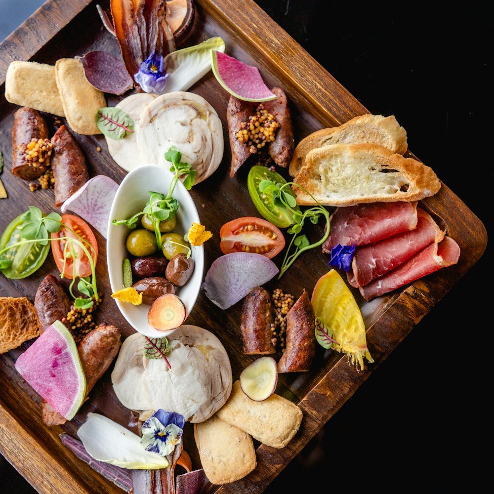 sliced meat with sliced vegetables and sliced vegetables on brown wooden chopping board