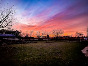 A peaceful backyard scene at sunset with garden tools resting nearby