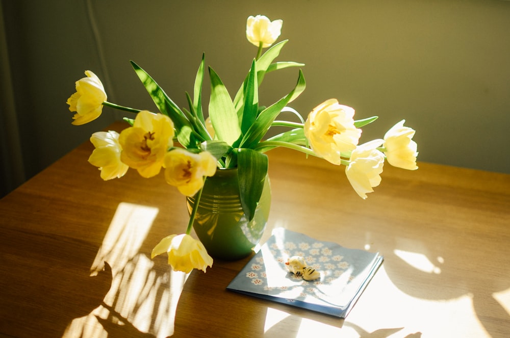 yellow tulips in green ceramic vase