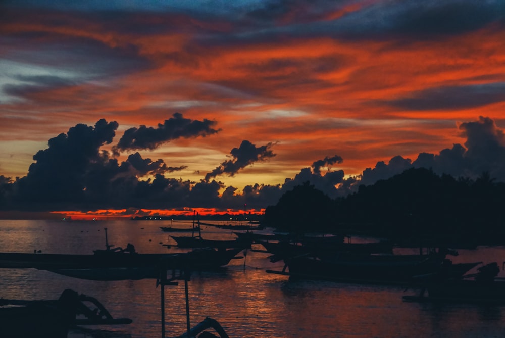 silhouette of boat on water during sunset