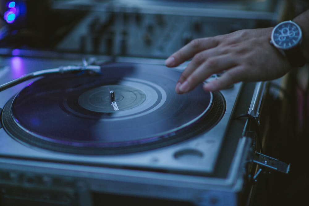 person playing black and silver vinyl record player