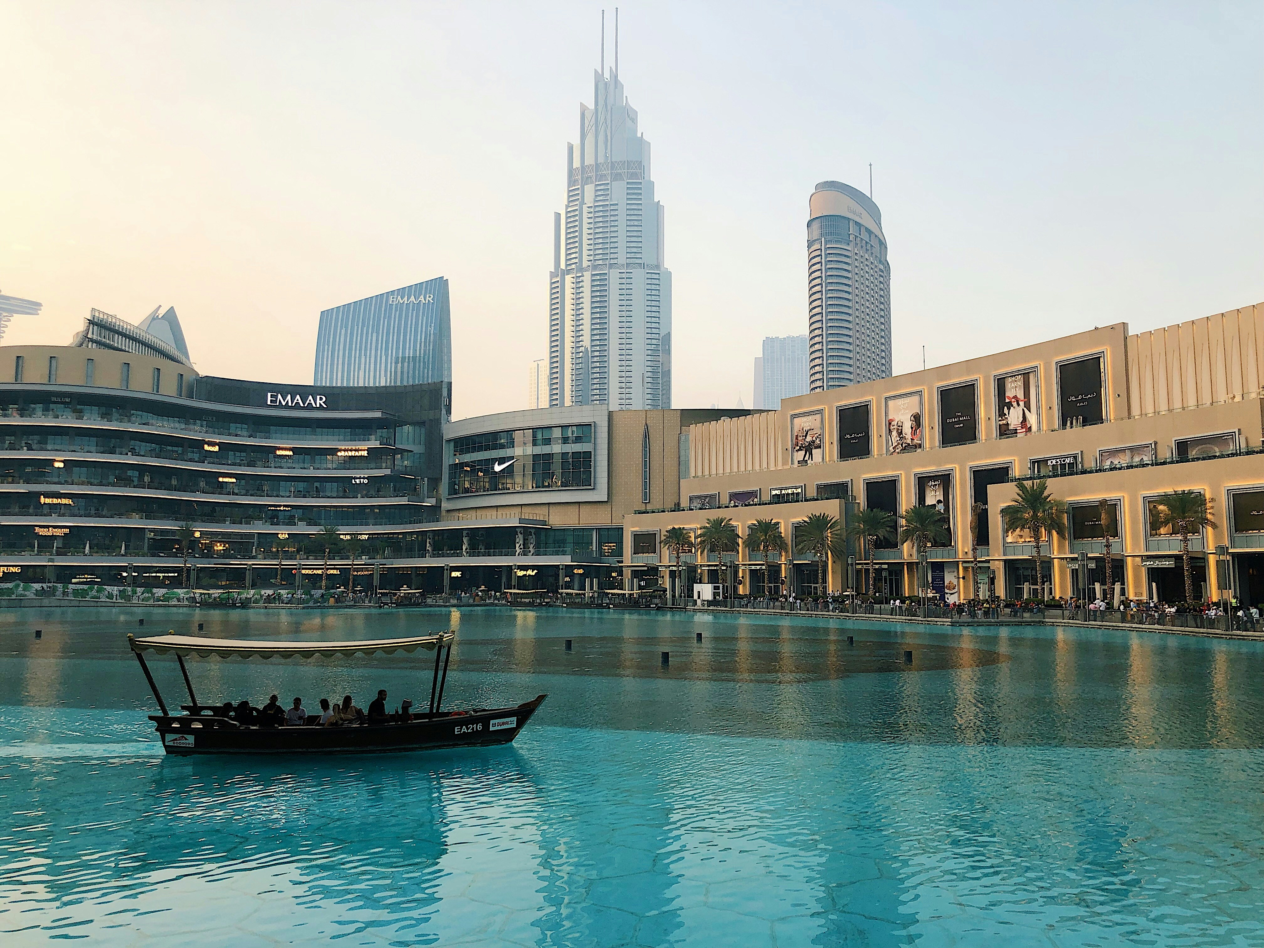 people riding on boat on water near high rise buildings during daytime