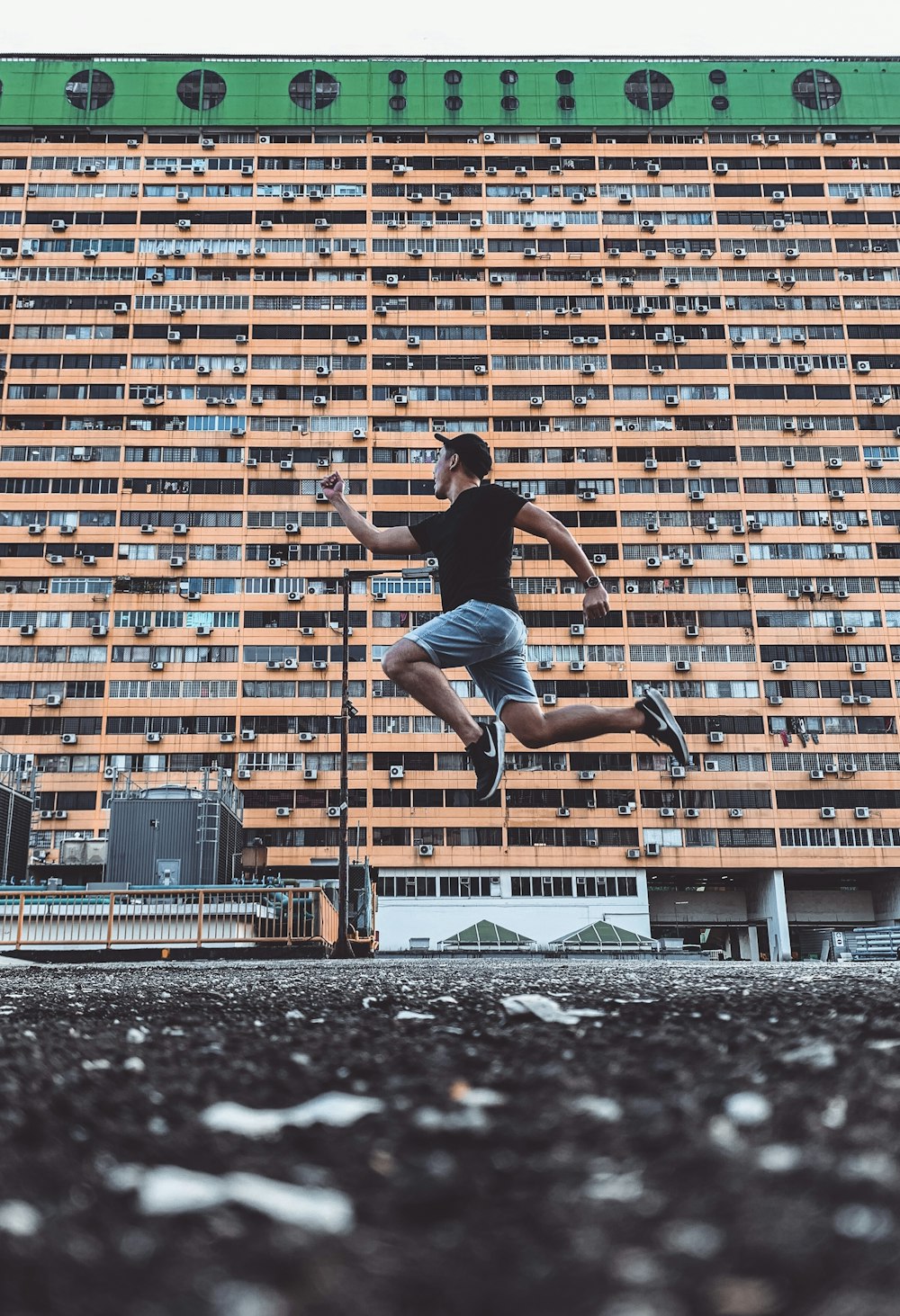 woman in black tank top and blue denim shorts jumping on snow covered ground during daytime