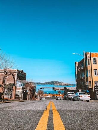 A bright Island Rent-A-Car vehicle parked near a scenic Victoria waterfront.