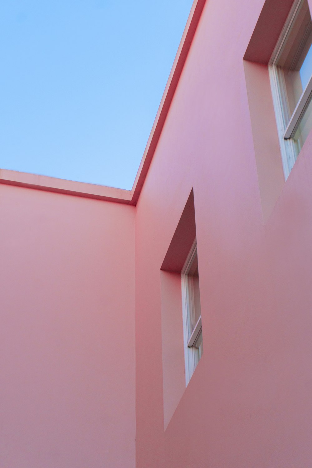 낮 동안 푸른 하늘 아래 분홍색 콘크리트 건물