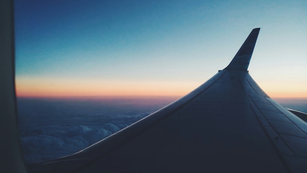 airplane window view of clouds during sunset