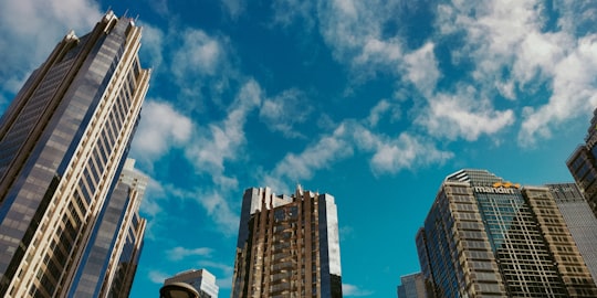 brown and white high rise building under blue sky during daytime in Jakarta Indonesia