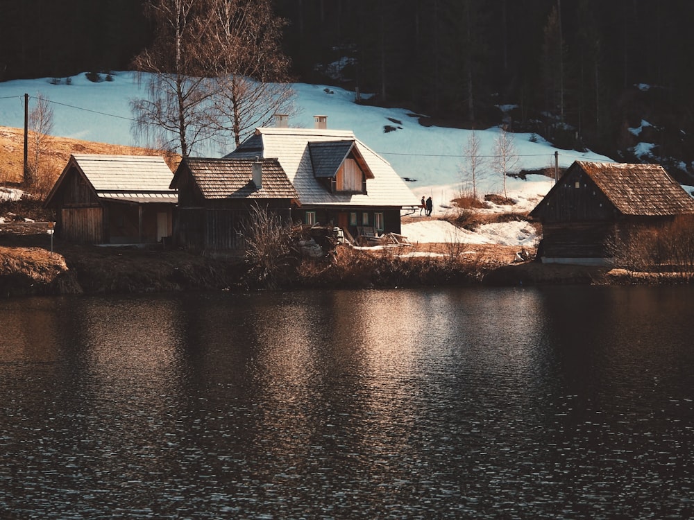 brown and white house beside river during daytime