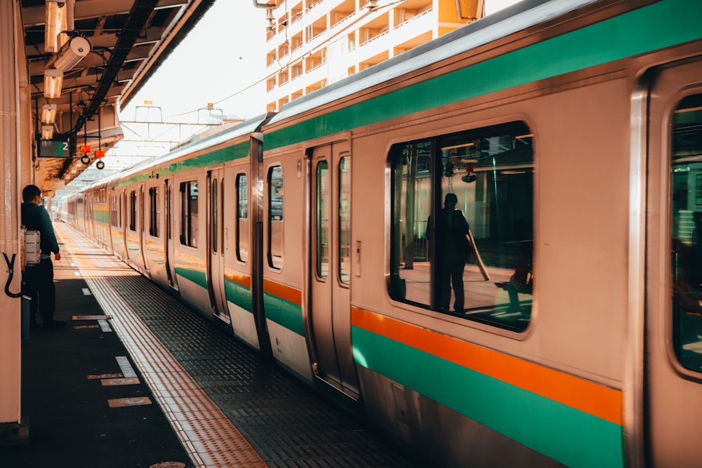 Tren blanco y verde en la estación de tren durante el día