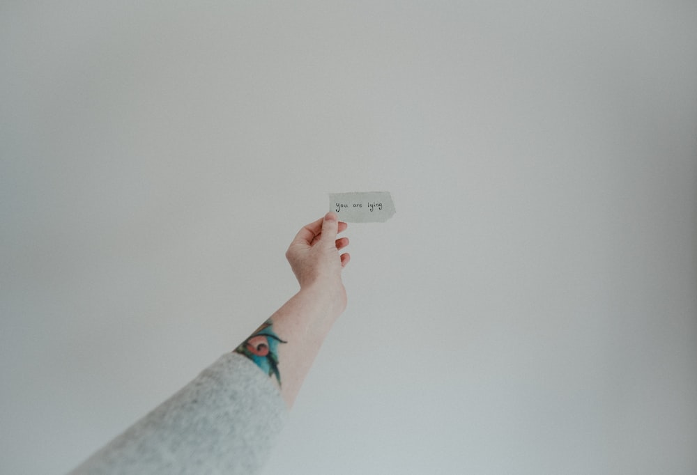 person holding white card with kanji text