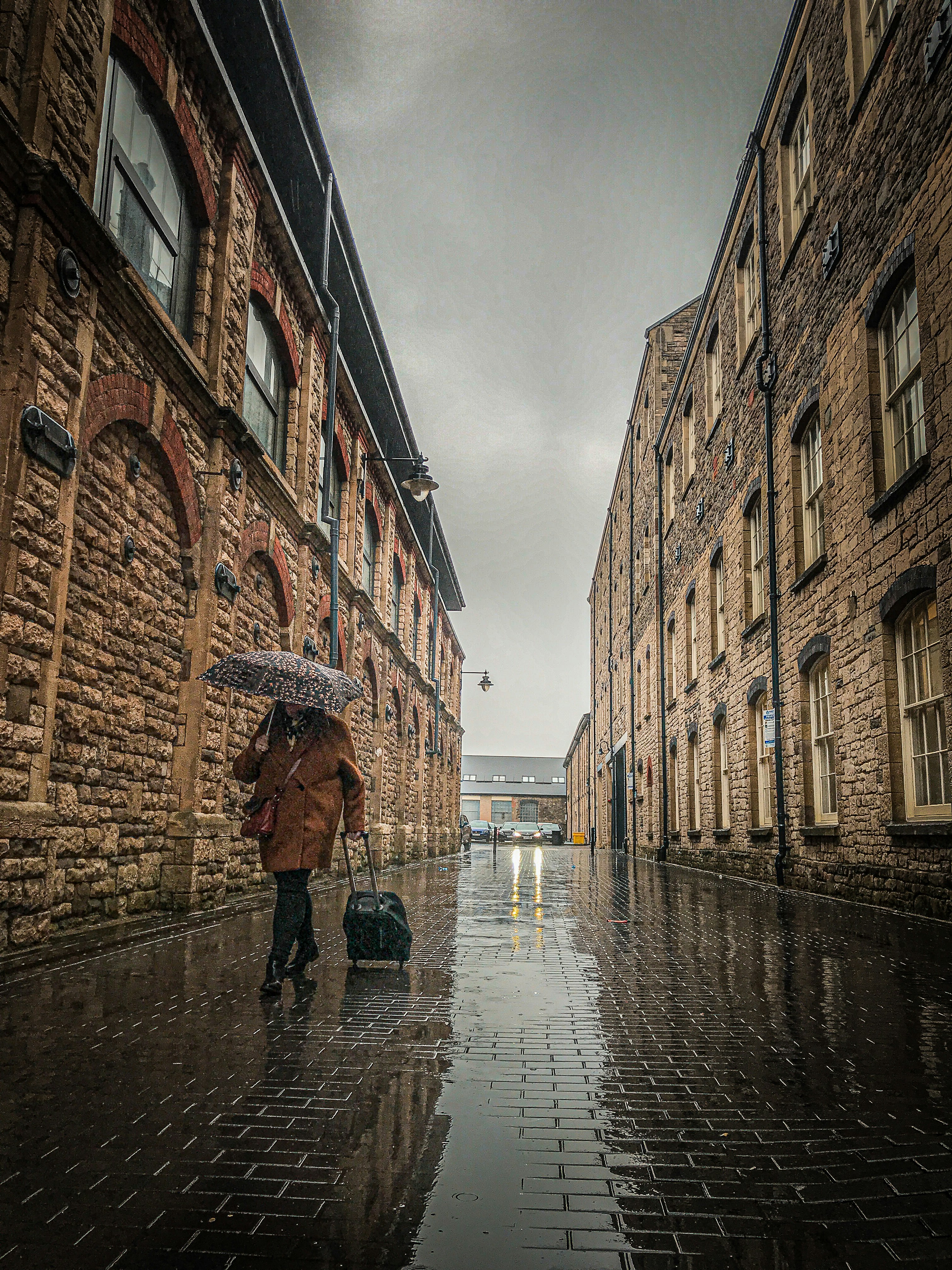 person in black jacket walking on sidewalk during daytime