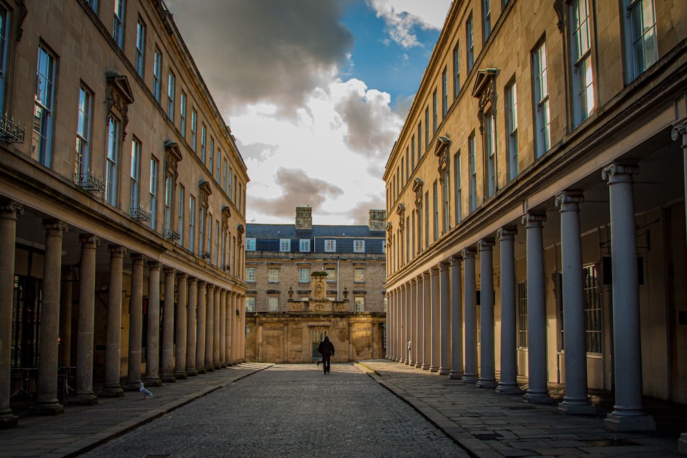 people walking on street between brown concrete building during daytime