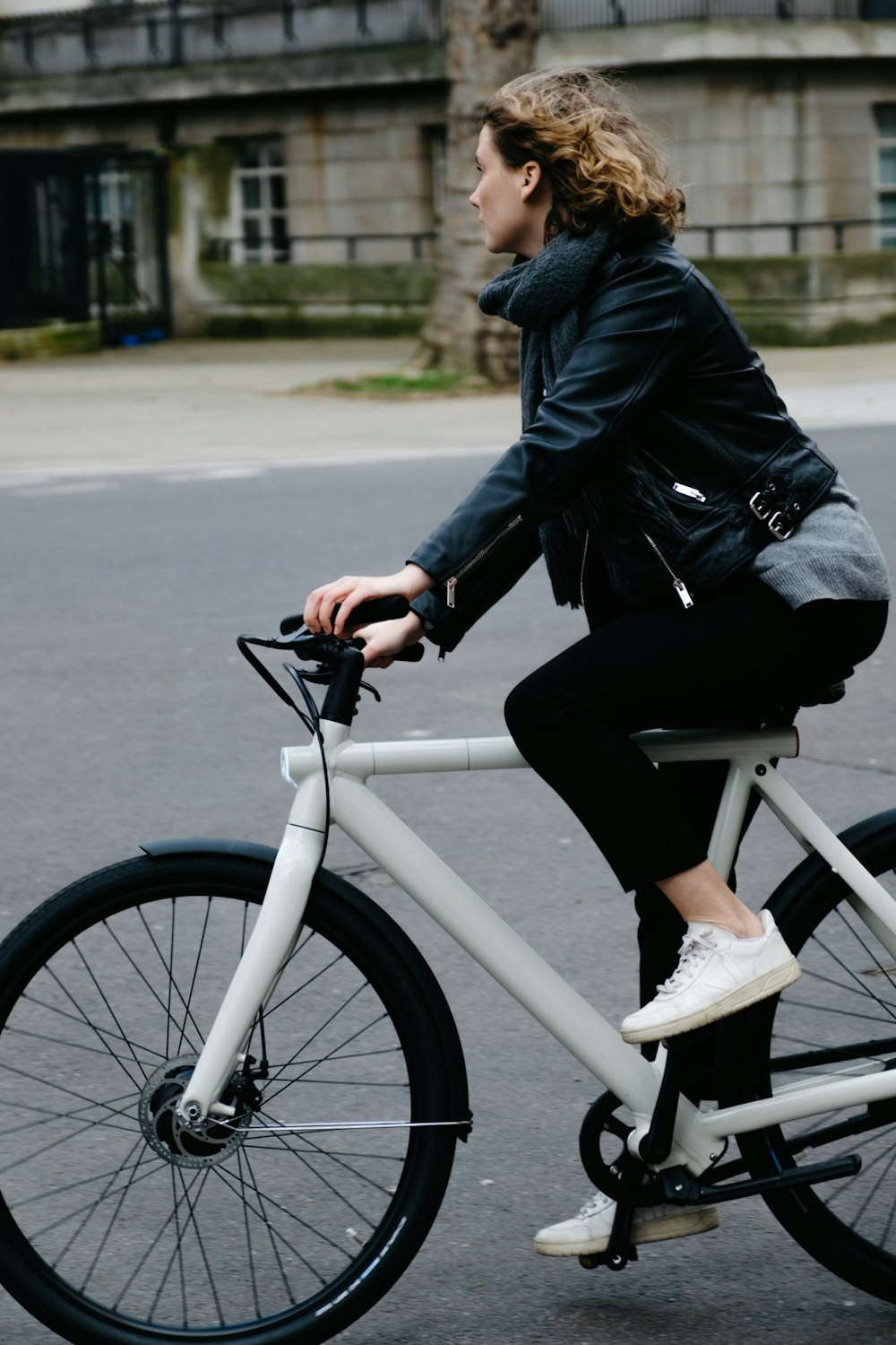 person in black jacket riding on white bicycle during daytime