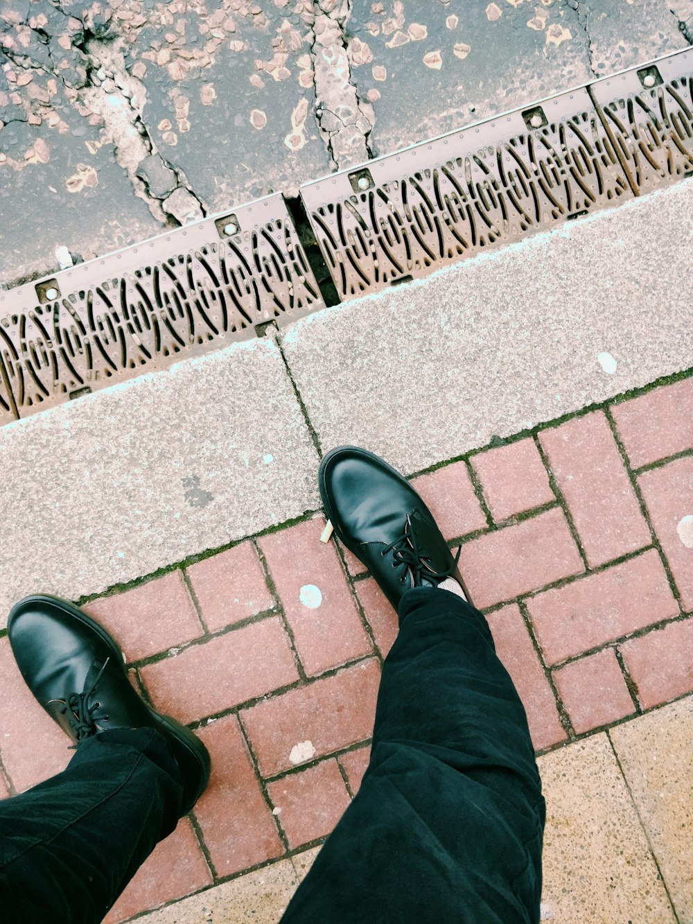 person in black pants and black leather shoes standing on brick pavement  photo – Free Grey Image on Unsplash