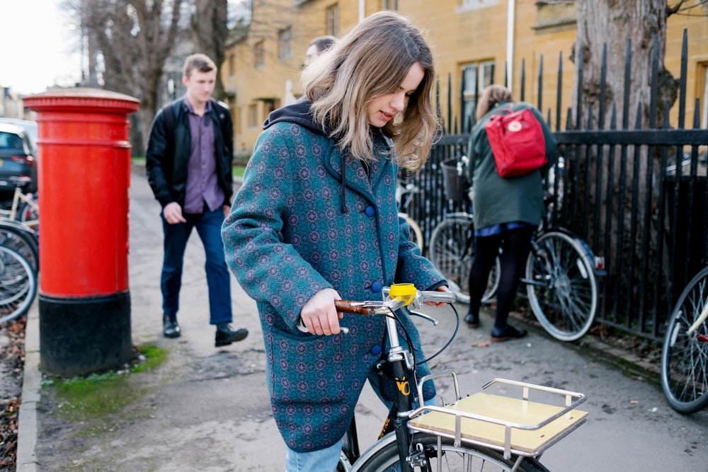 femme en pull gris faisant du vélo pendant la journée